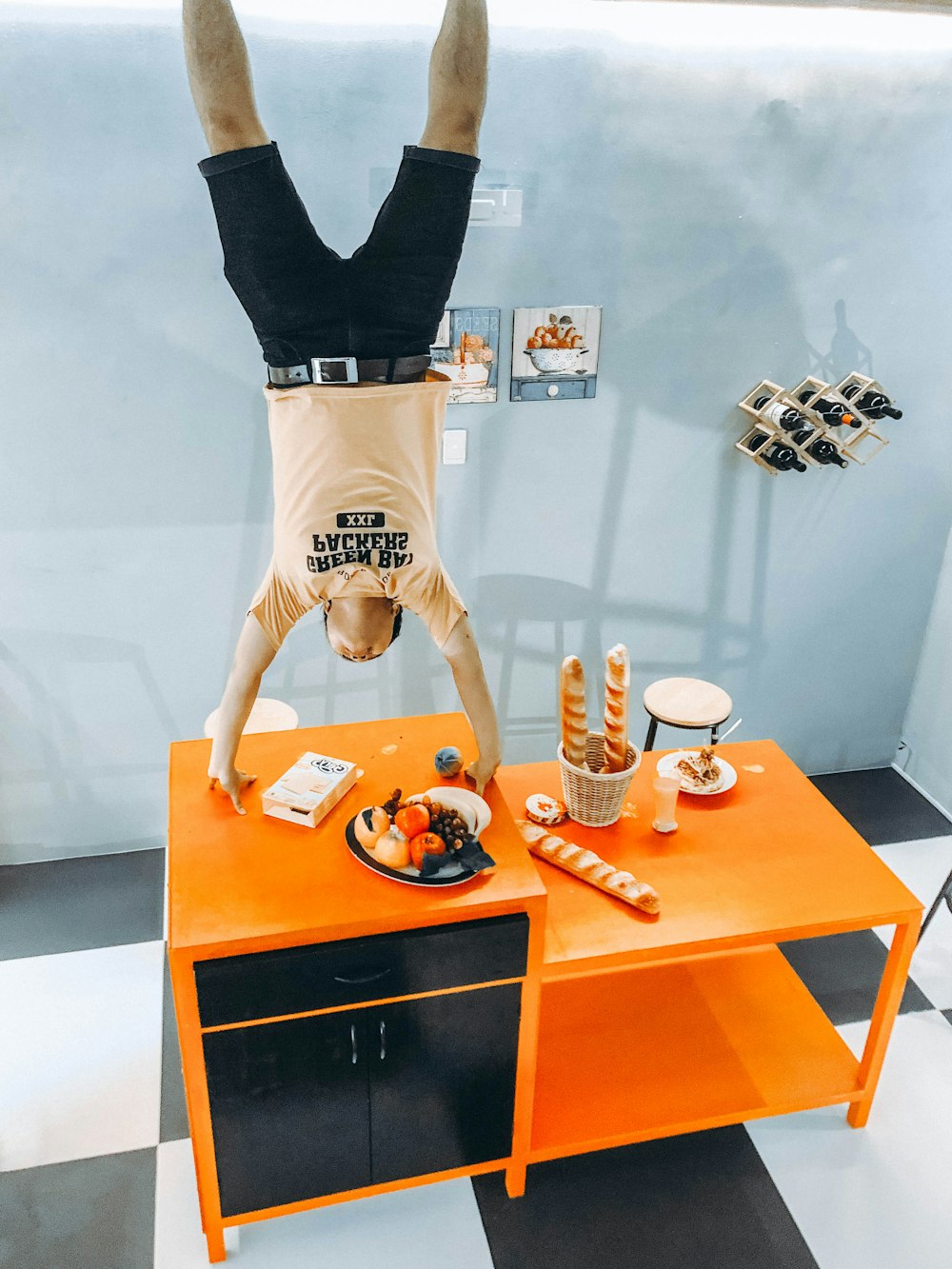 man standing upside down in orange and black cabinet