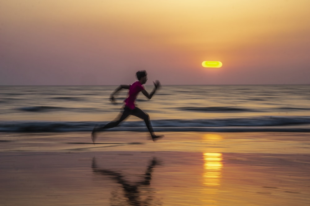 man running along seashore during golden hour