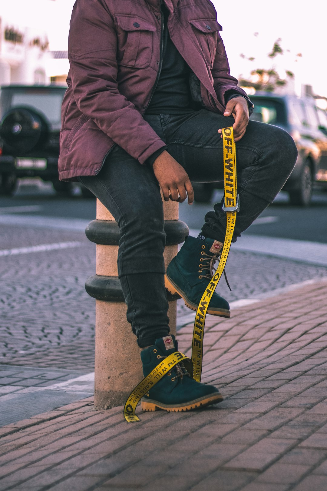 person sitting on column while holding yellow strap