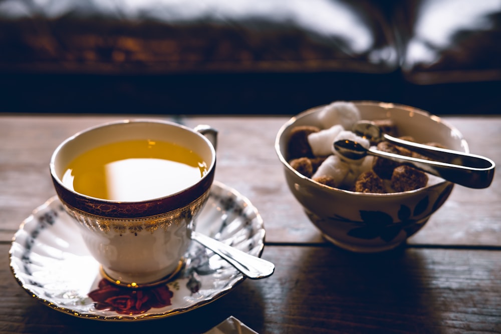 juice in cup on saucer beside bowl