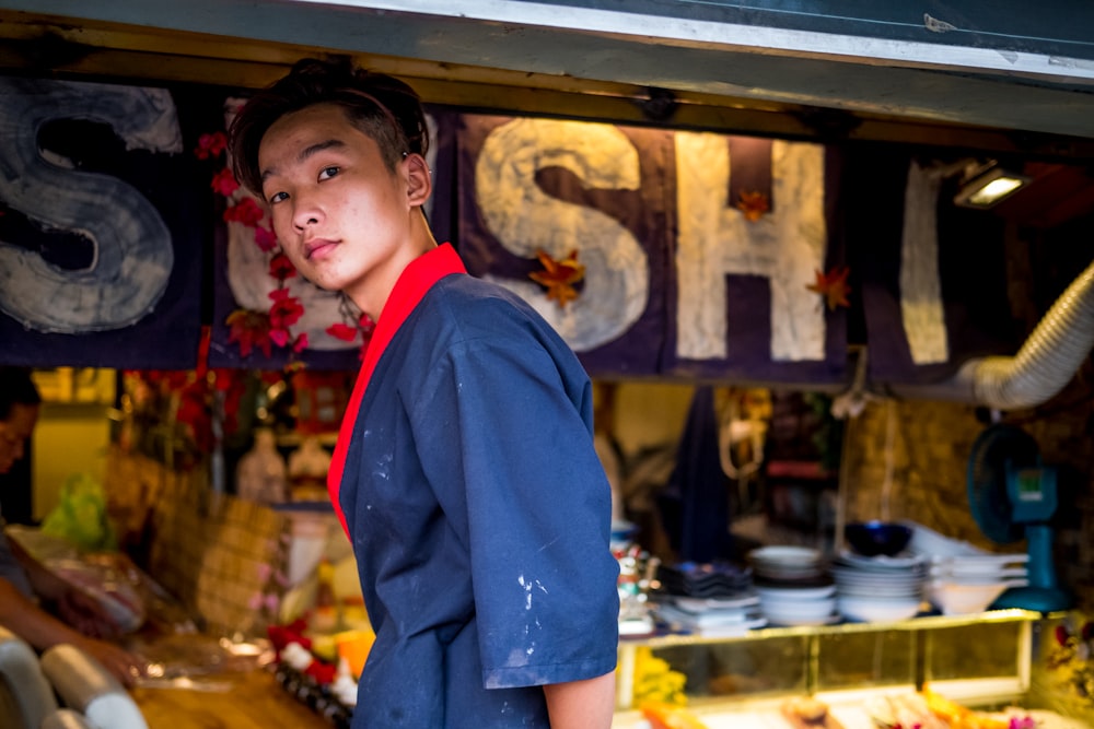 man standing in front sushi storefront