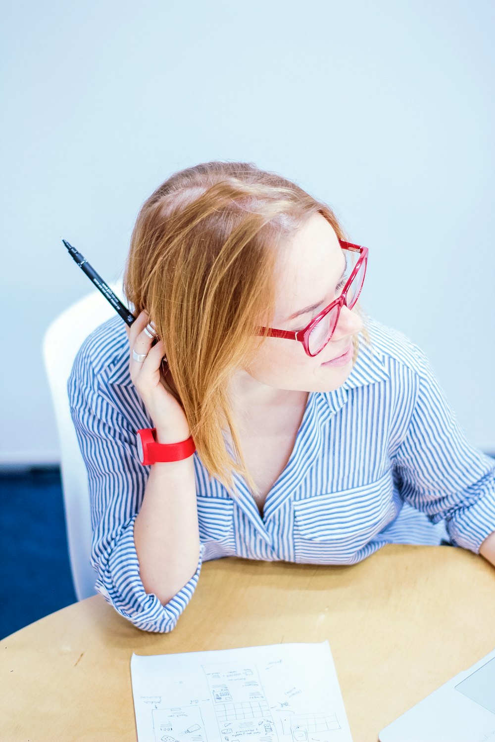 woman sitting in front of table while right hand resting