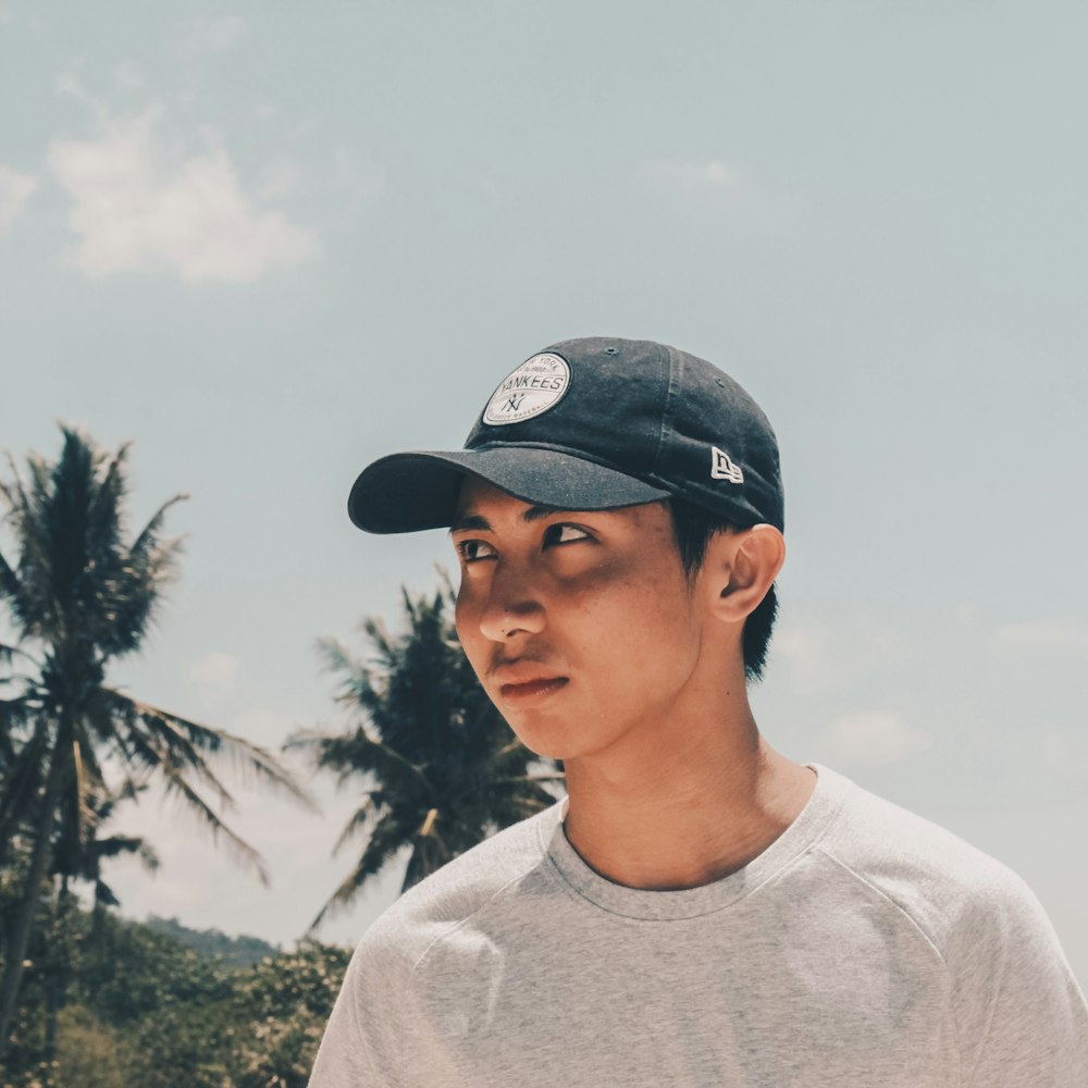 man wearing white crew-neck top and black and white cap