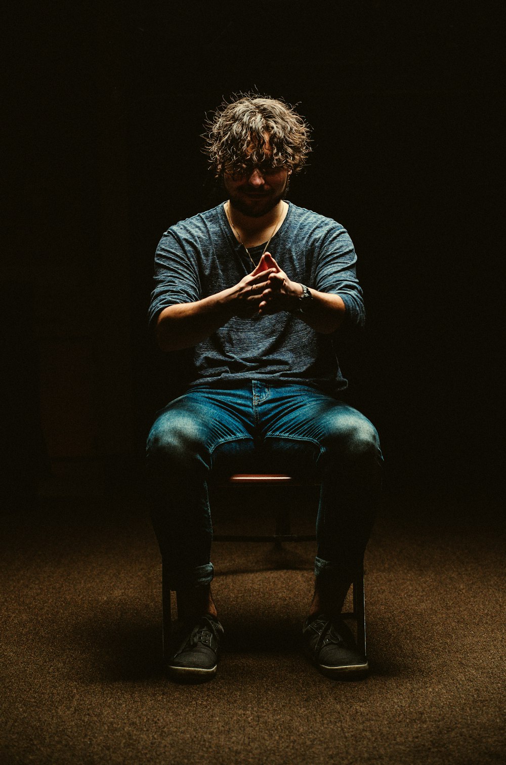 man sitting on chair inside dim room