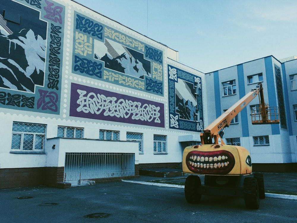 yellow crane truck across white building