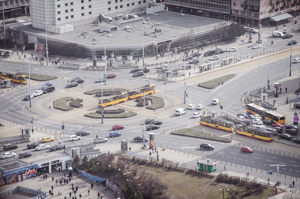 different vehicles on road near buildings and people walking on pathway