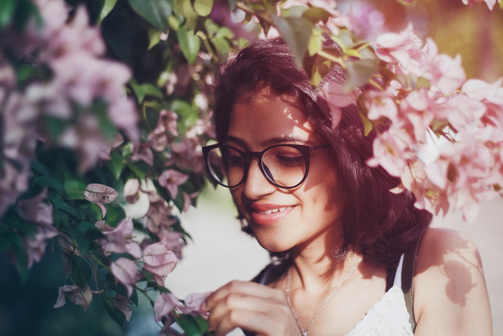 woman wearing eyeglasses picking flowers
