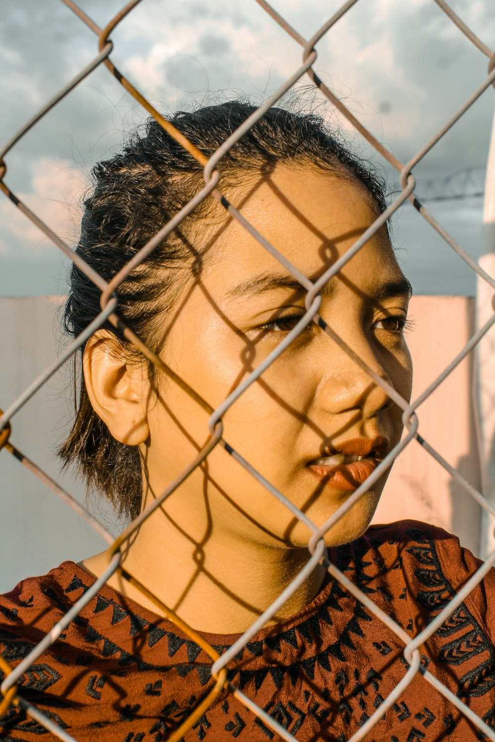 woman standing behind interlocking fence