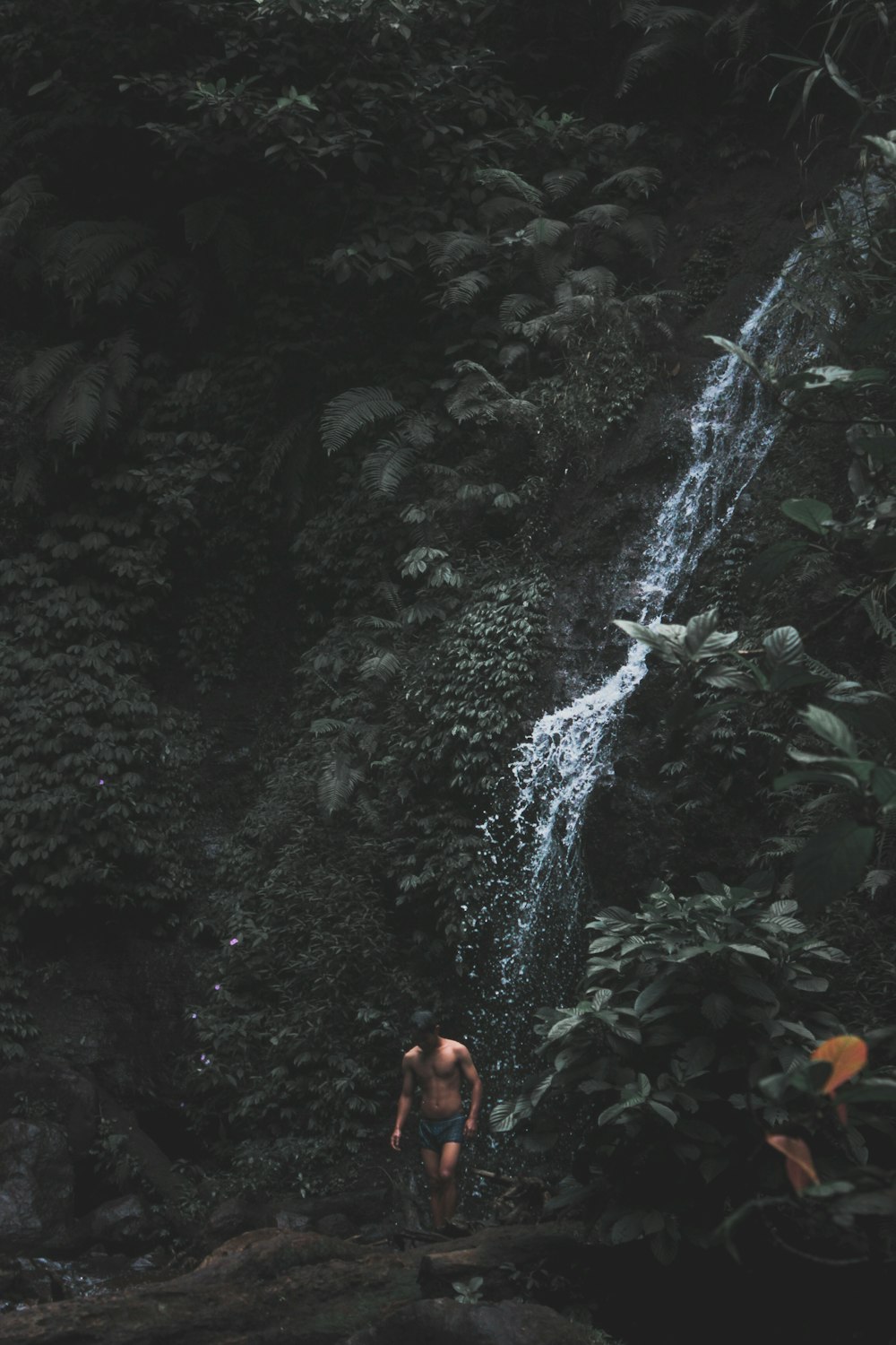 man standing in front of waterfalls