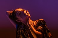 A striking pose with dramatic black drapery contrasting against luminous skin tones.