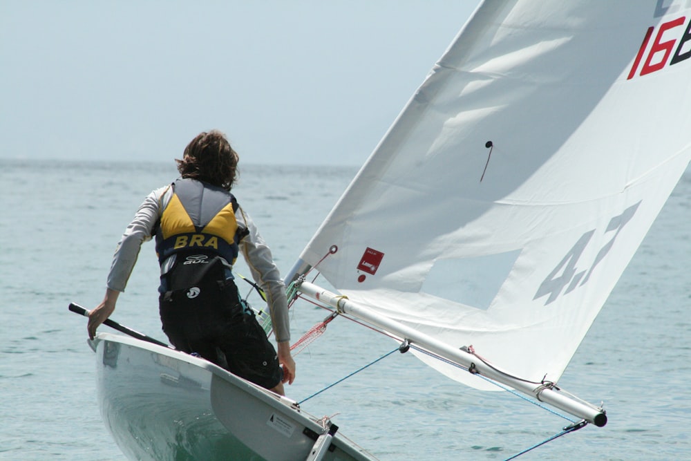man riding white sailboat