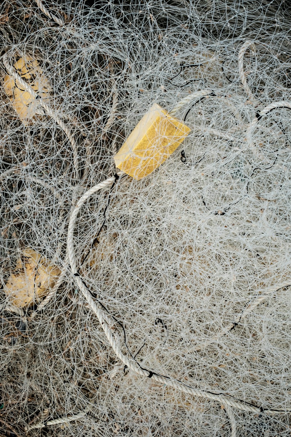 a piece of yellow and white wire next to a yellow object