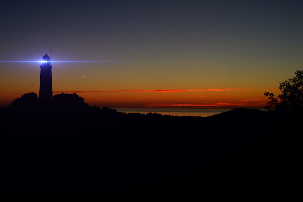 silhouette of lights on lighthouse during golden hour