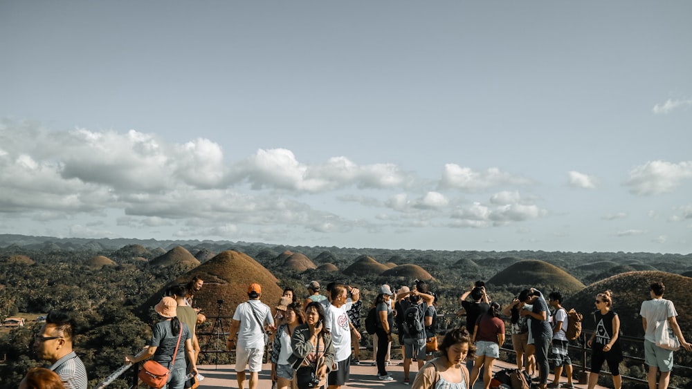 people standing in front of green mountain hills