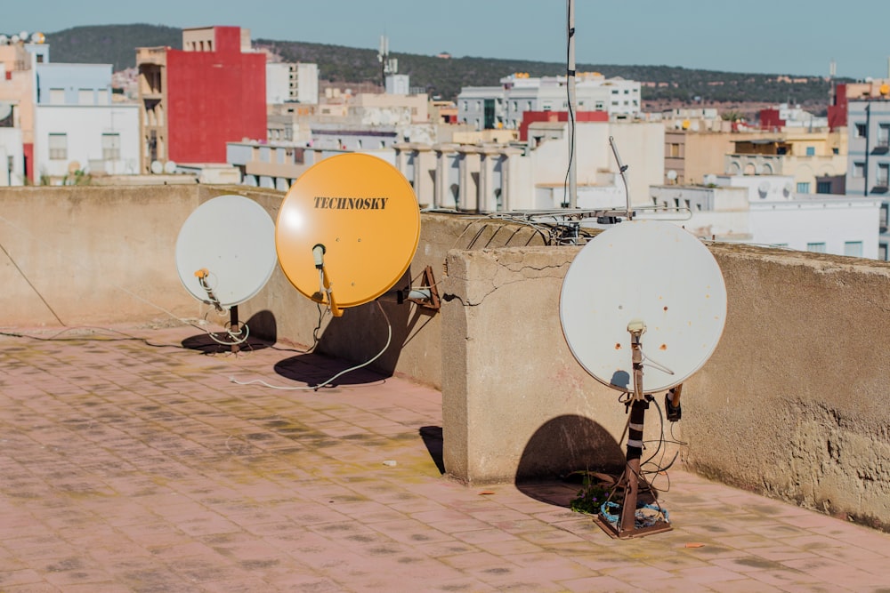 three white and yellow satellite dishes