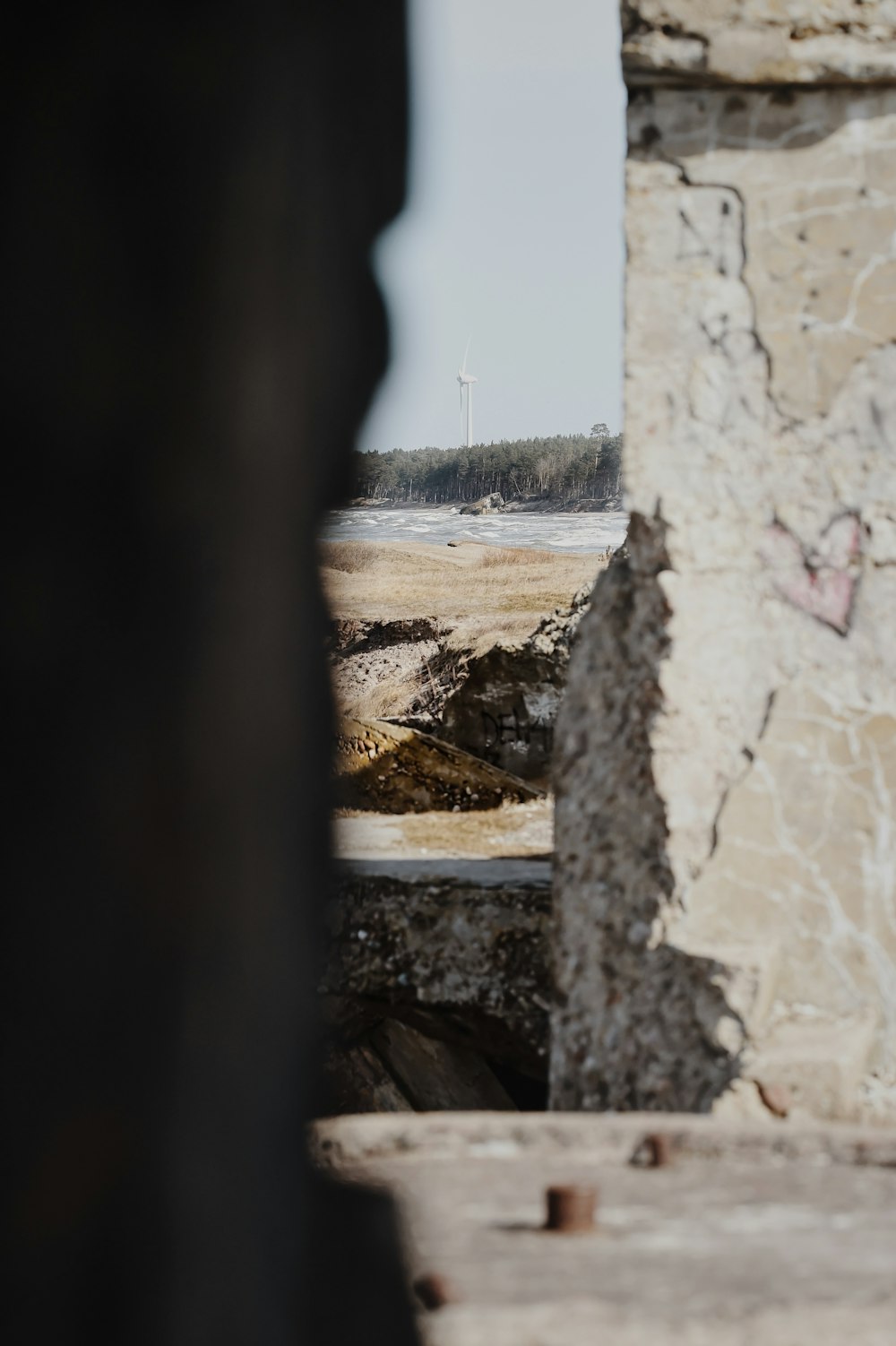 a view of a lighthouse through a hole in a wall