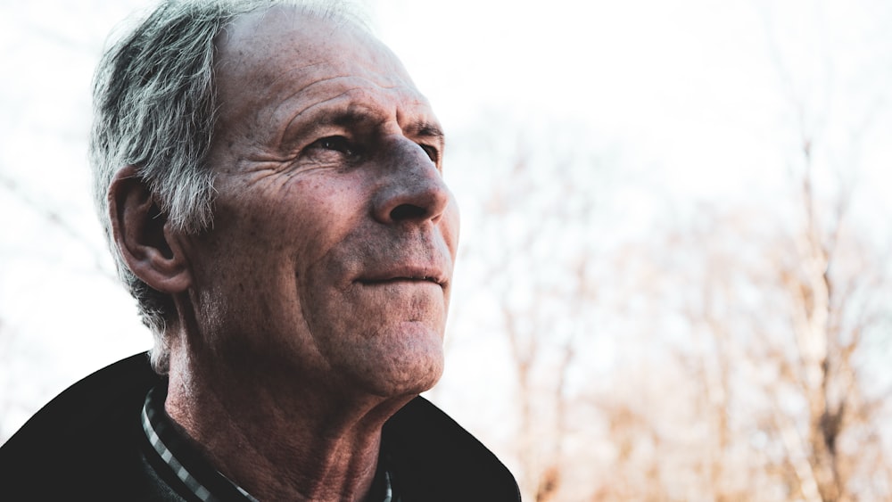 man in black top near bare trees