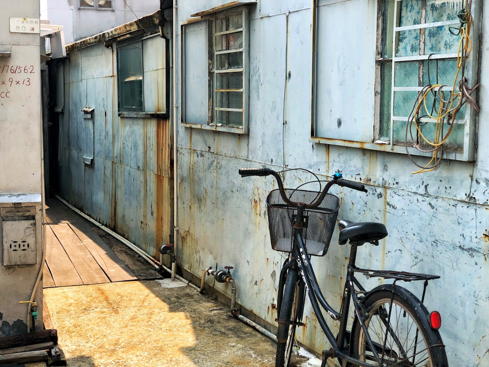 black cruiser bike parked beside white concrete house