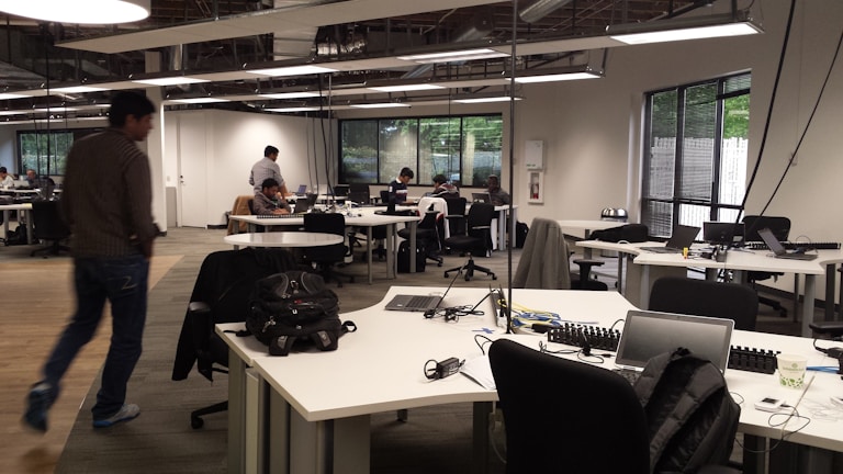 A panoramic view of kaspi.kz’s open-plan workspace featuring clean design and employees focused on their screens.