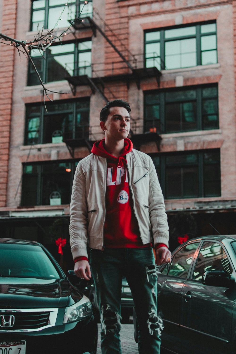 man in brown jacket standing beside vehicles