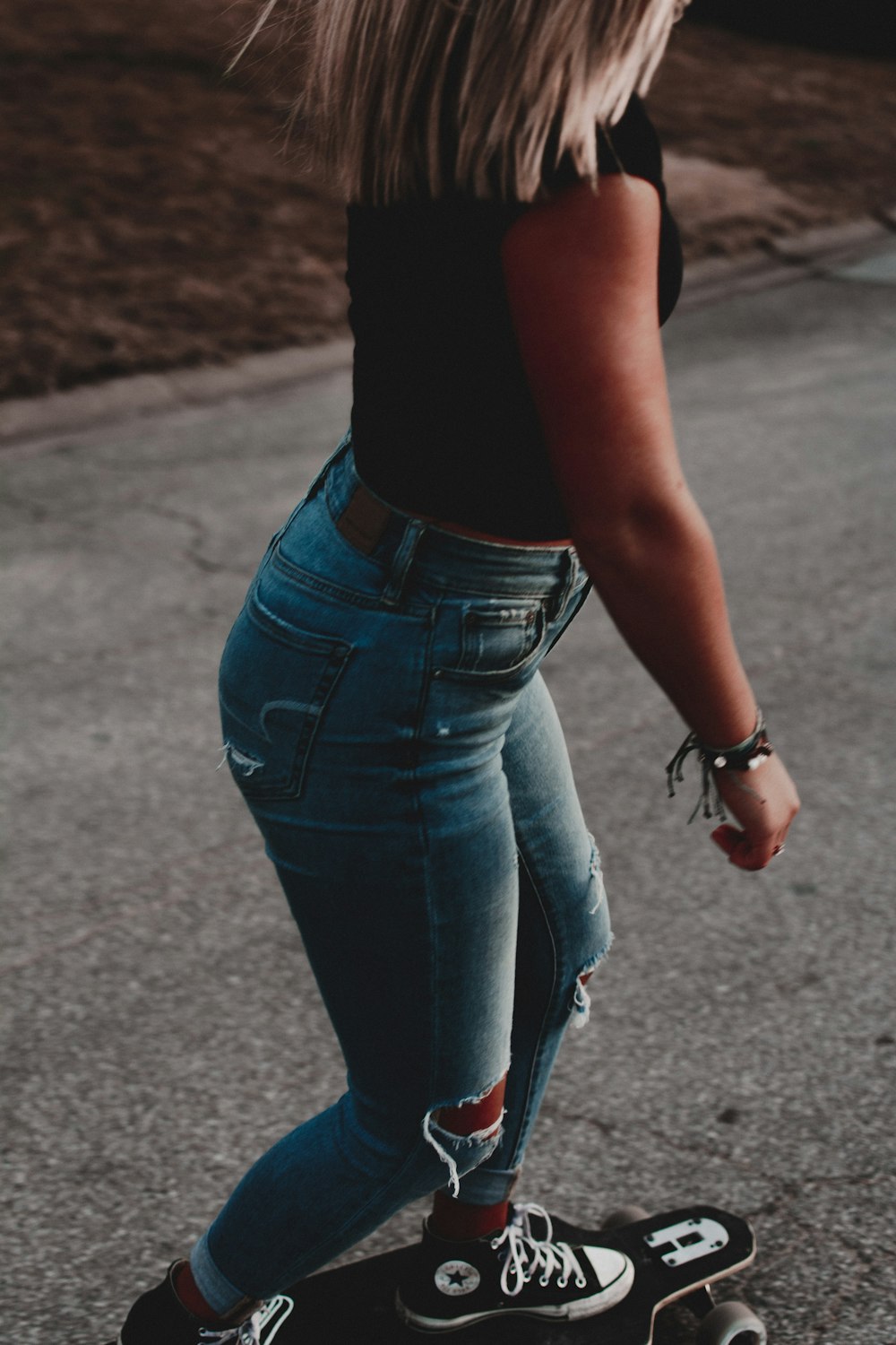 woman riding on black longboard outdoors