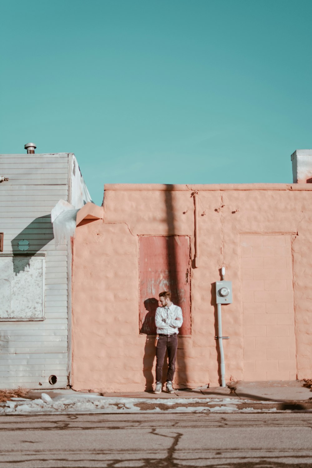 man standing in front of beige wall