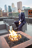 sitting man wearing blue coat beside yellow fire