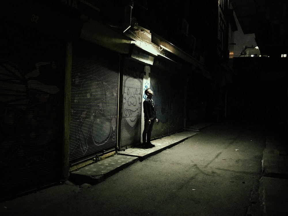 man standing under light during nighttime