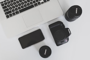 A stylish flat lay of influencer tools: camera, laptop, and notes on a minimalist desk.