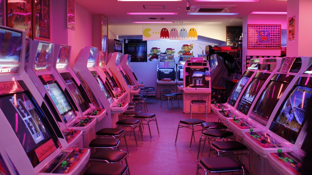 turned-on arcade machines with stools,