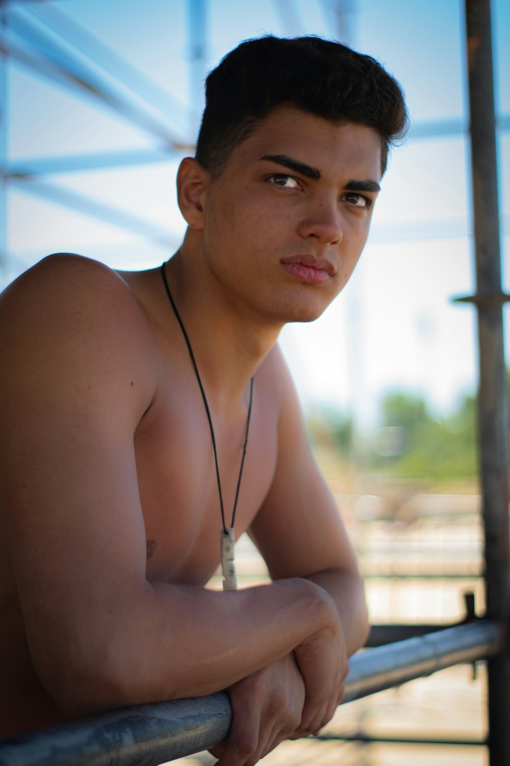 topless man leaning on railing