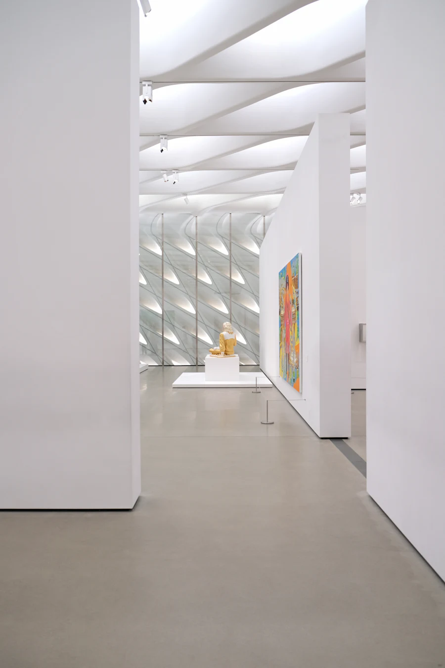 A white gallery room, a single work on the far wall and a plinth in the middle.