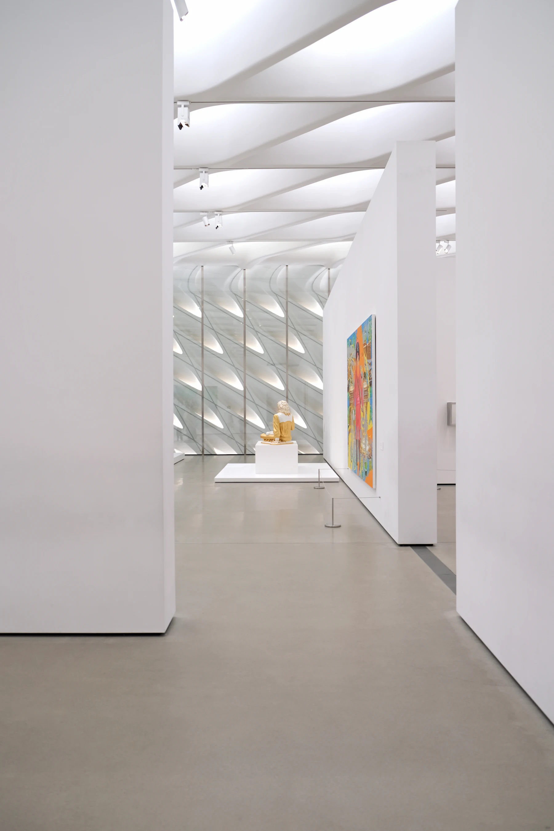 A white gallery room, a single work on the far wall and a plinth in the middle.