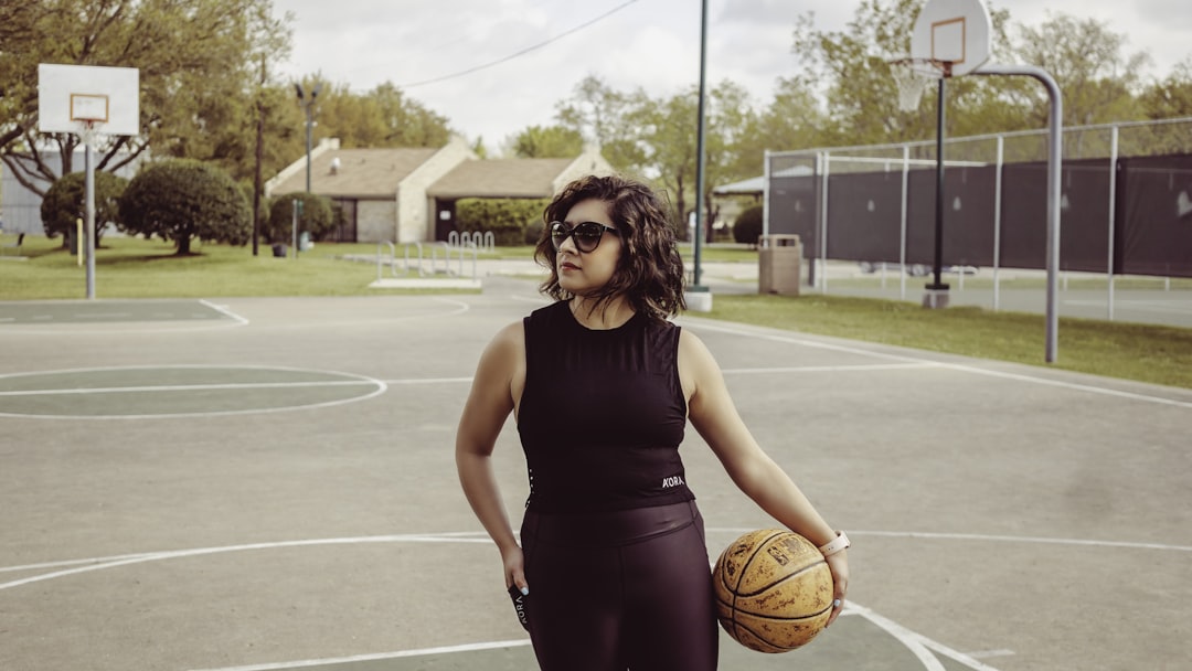 woman standing outdoors holding basketball,