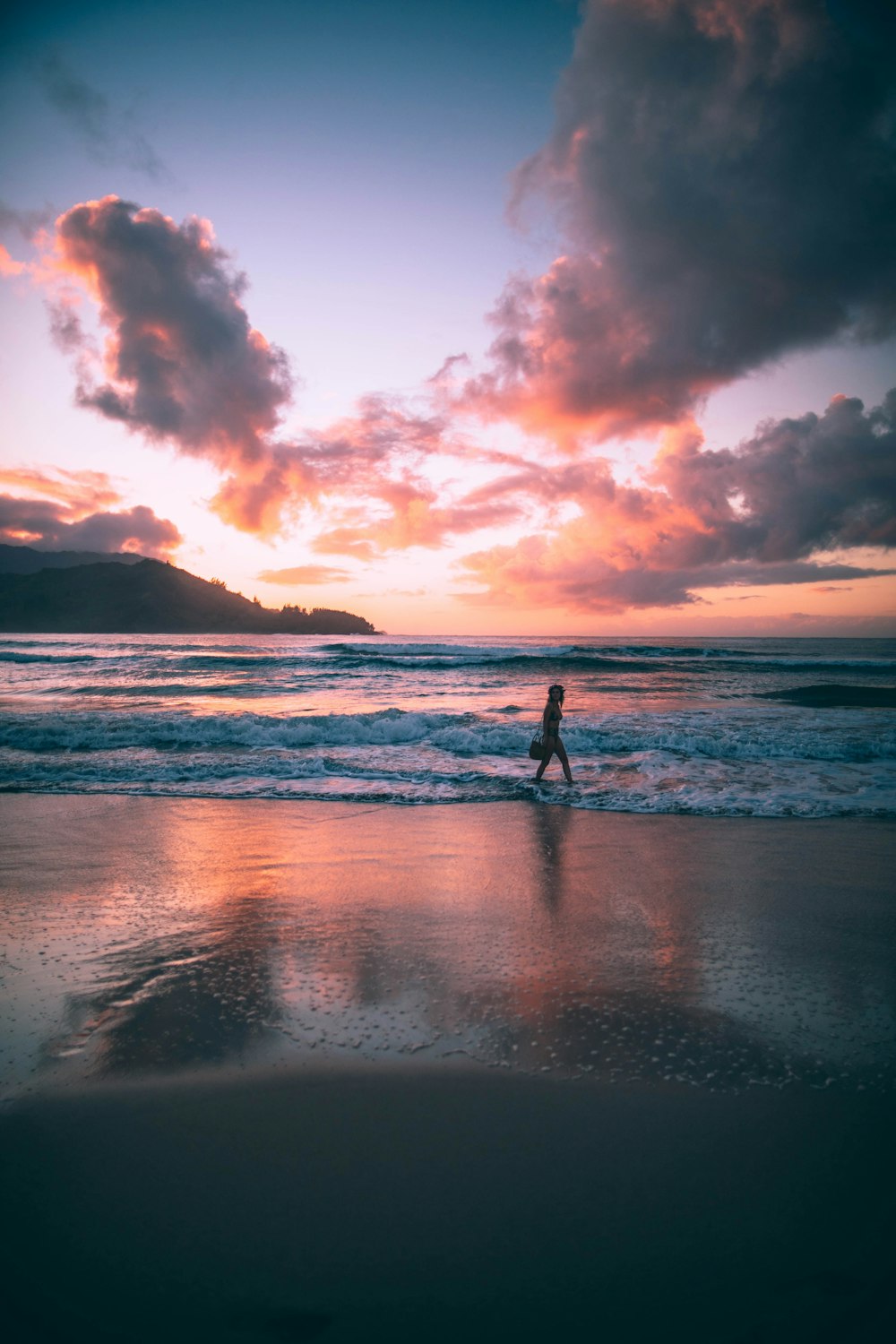 Mujer de pie sobre las olas del mar durante la hora dorada