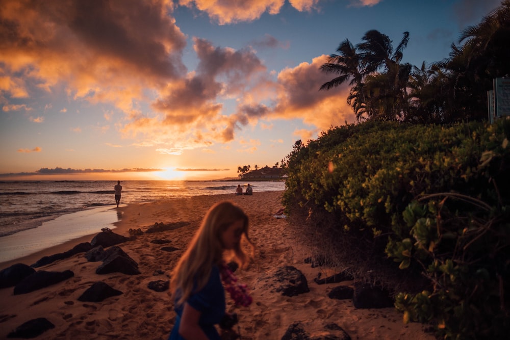 woman walking near hedge on beach