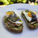 Golden sweetcorn fritters topped with avocado, crispy bacon, black bean salsa fresca, and a perfectly cooked free-range egg.