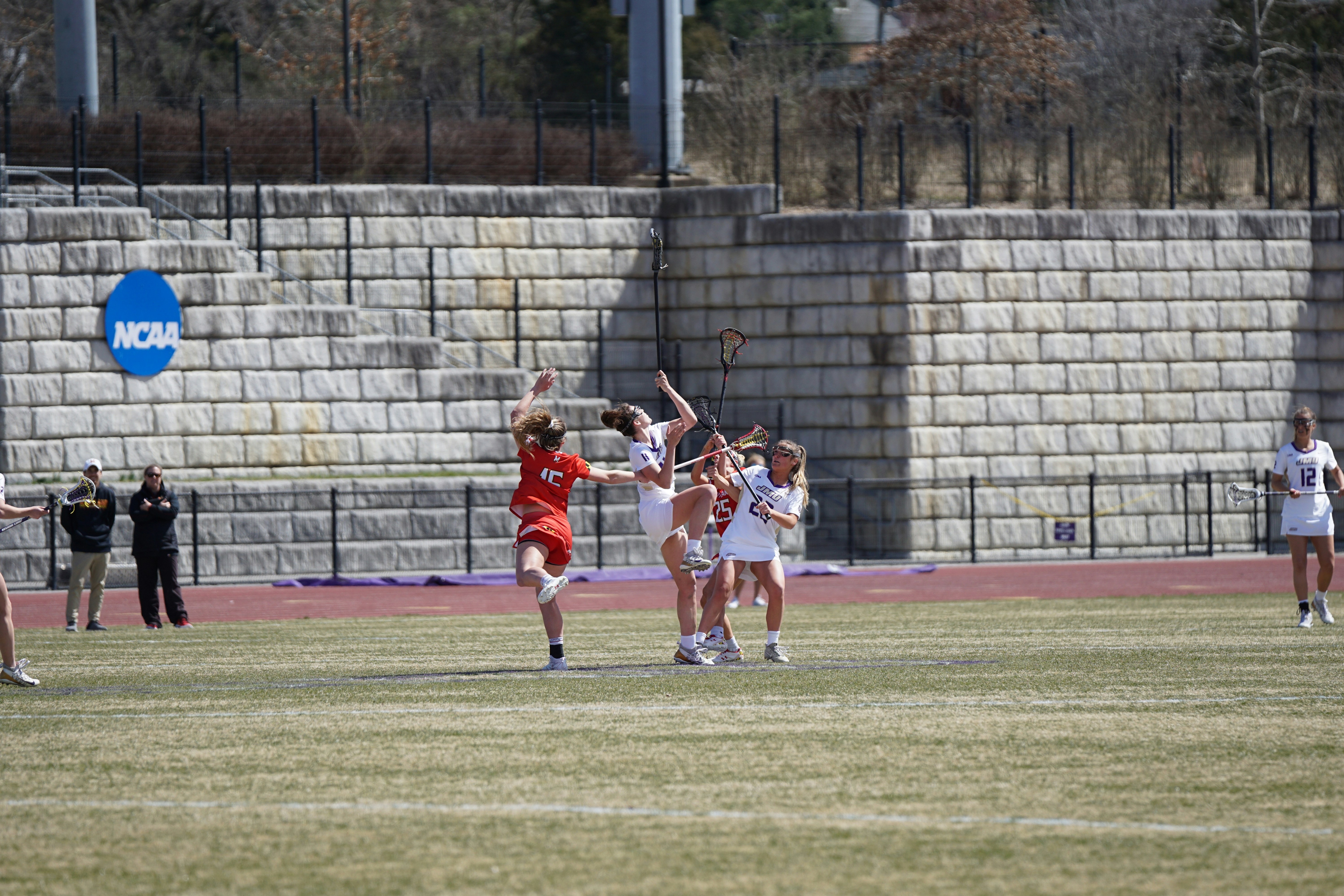 wanita bermain lacrosse di lapangan
