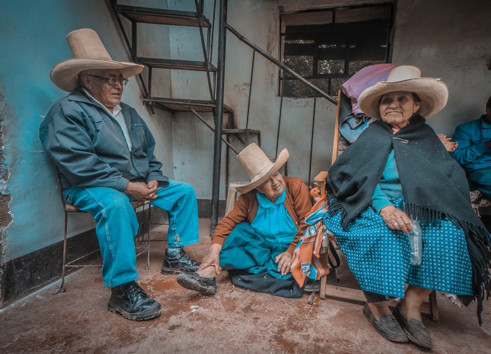 three person sitting near staircase