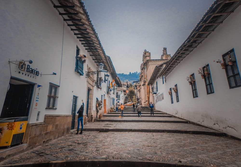 pessoas caminhando entre casas brancas durante o dia