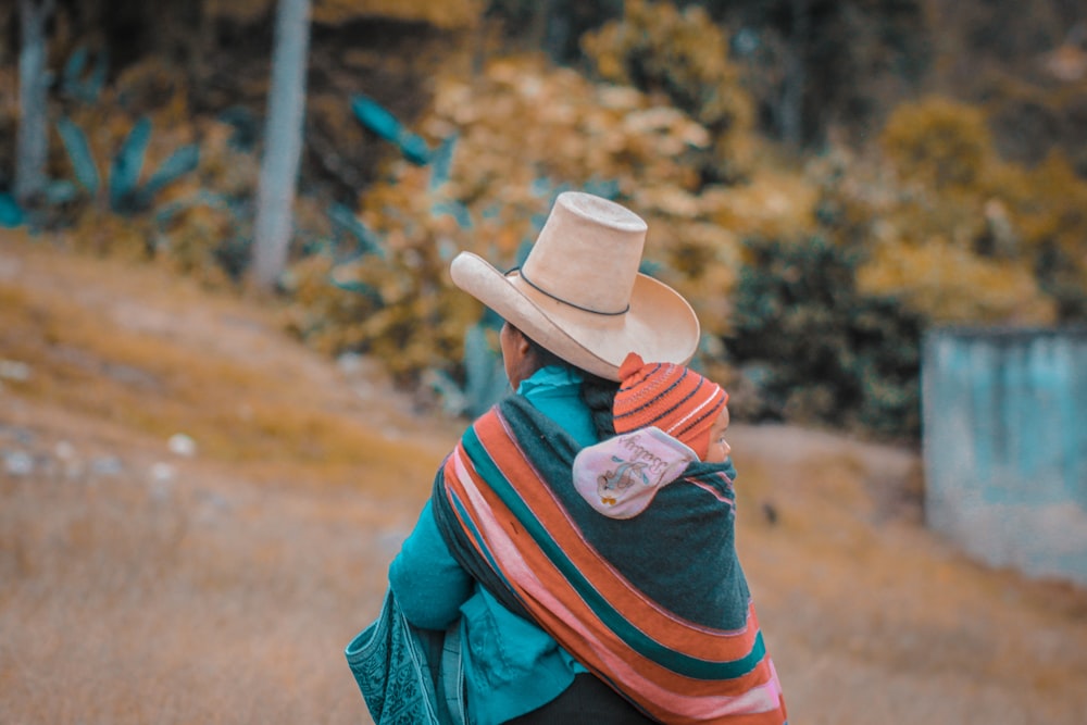 person sitting wearing brown hat outdoors during daytime