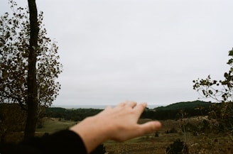 A handshake over a land contract with a background of open, undeveloped land.