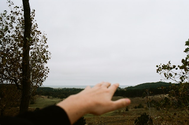 A handshake over a land contract with a background of open, undeveloped land.