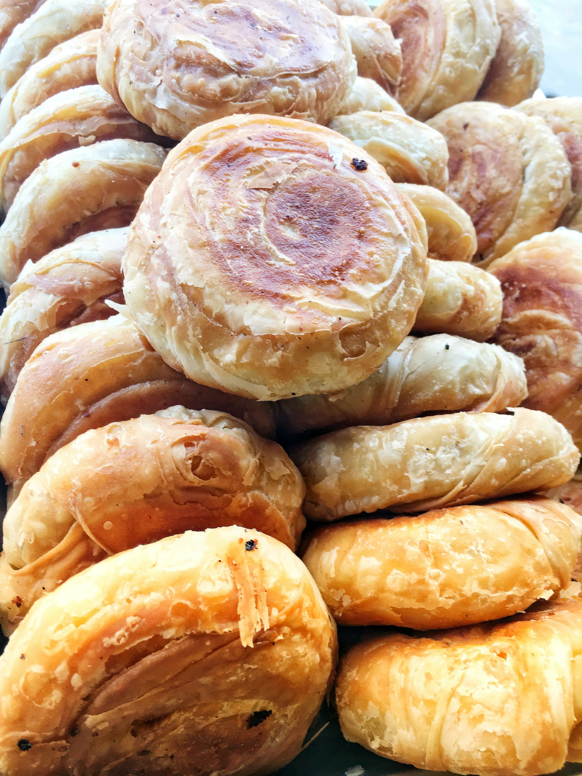 Golden, crispy savory pastries freshly baked and cooling on a traditional kitchen counter