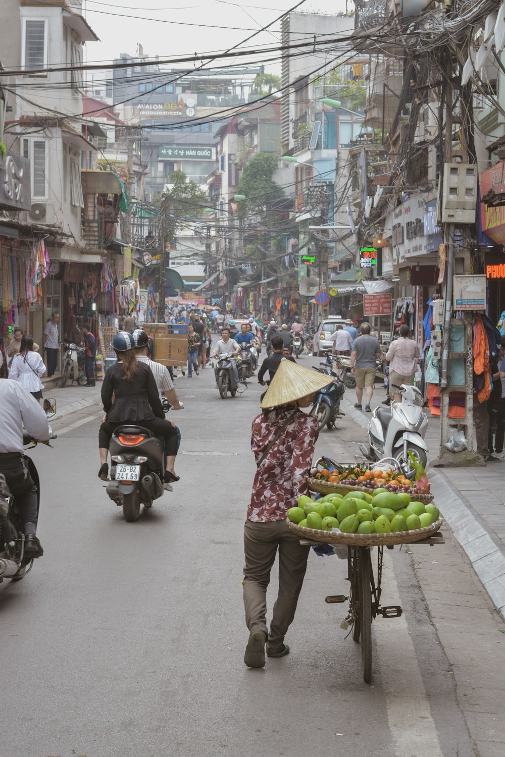 person walking with bicycle on road