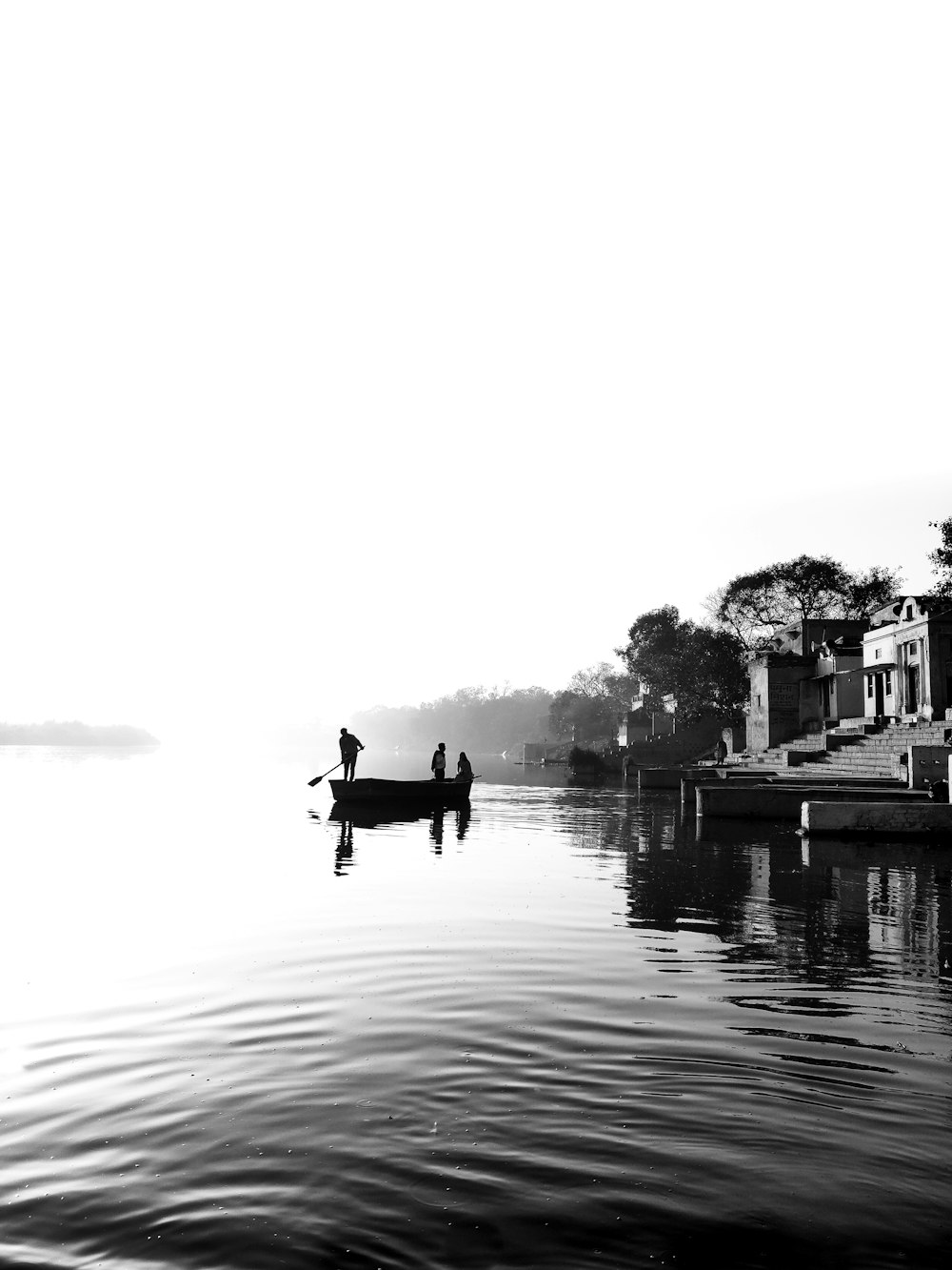 grayscale photography of three person on boat
