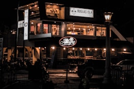 A calm, inviting storefront with the La Lagunita Auto sign glowing softly at dusk.