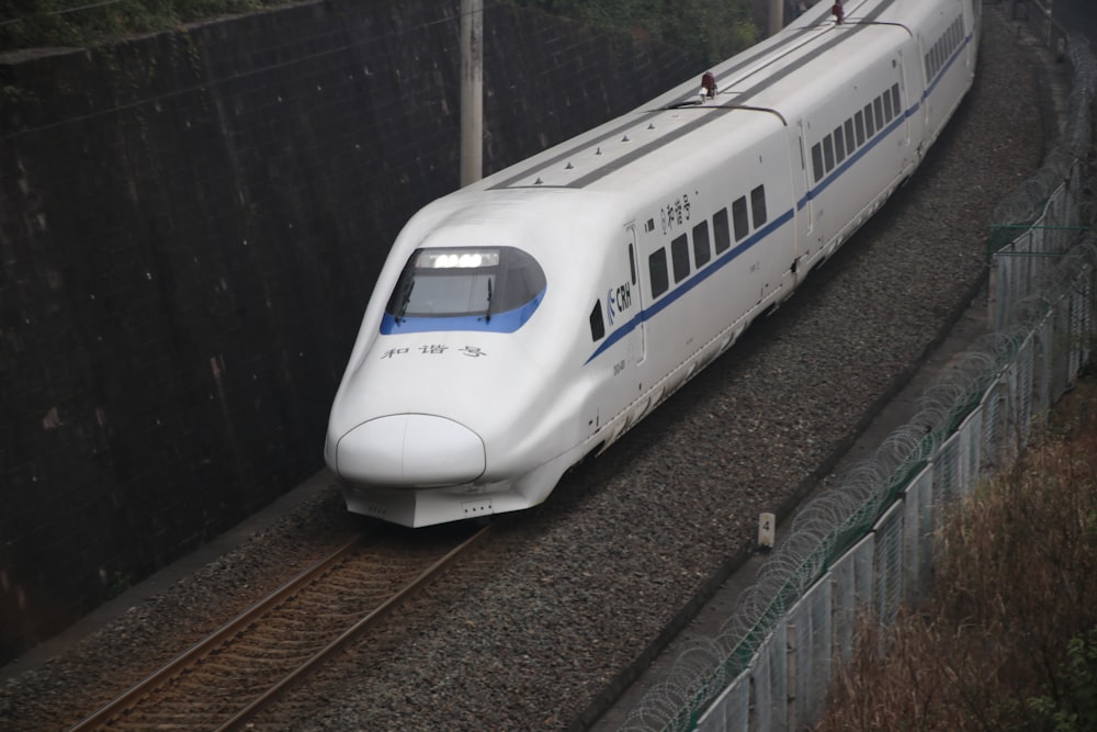 white and blue train on railway