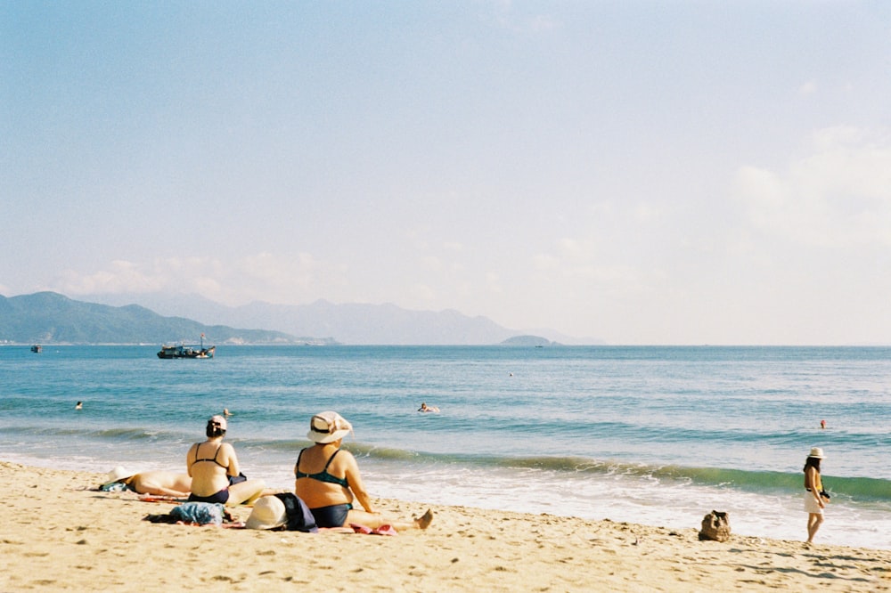 people sitting on seashore
