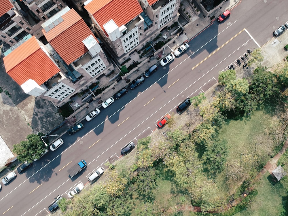 aerial photography of vehicles on street beside buildings